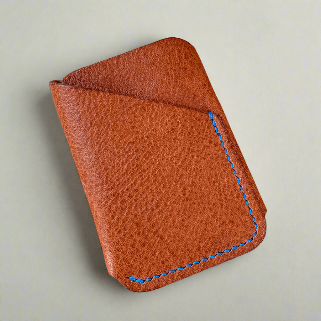 A lovely tan wrap ard wallet in sustainable leather with hand stitching in cobalt blue