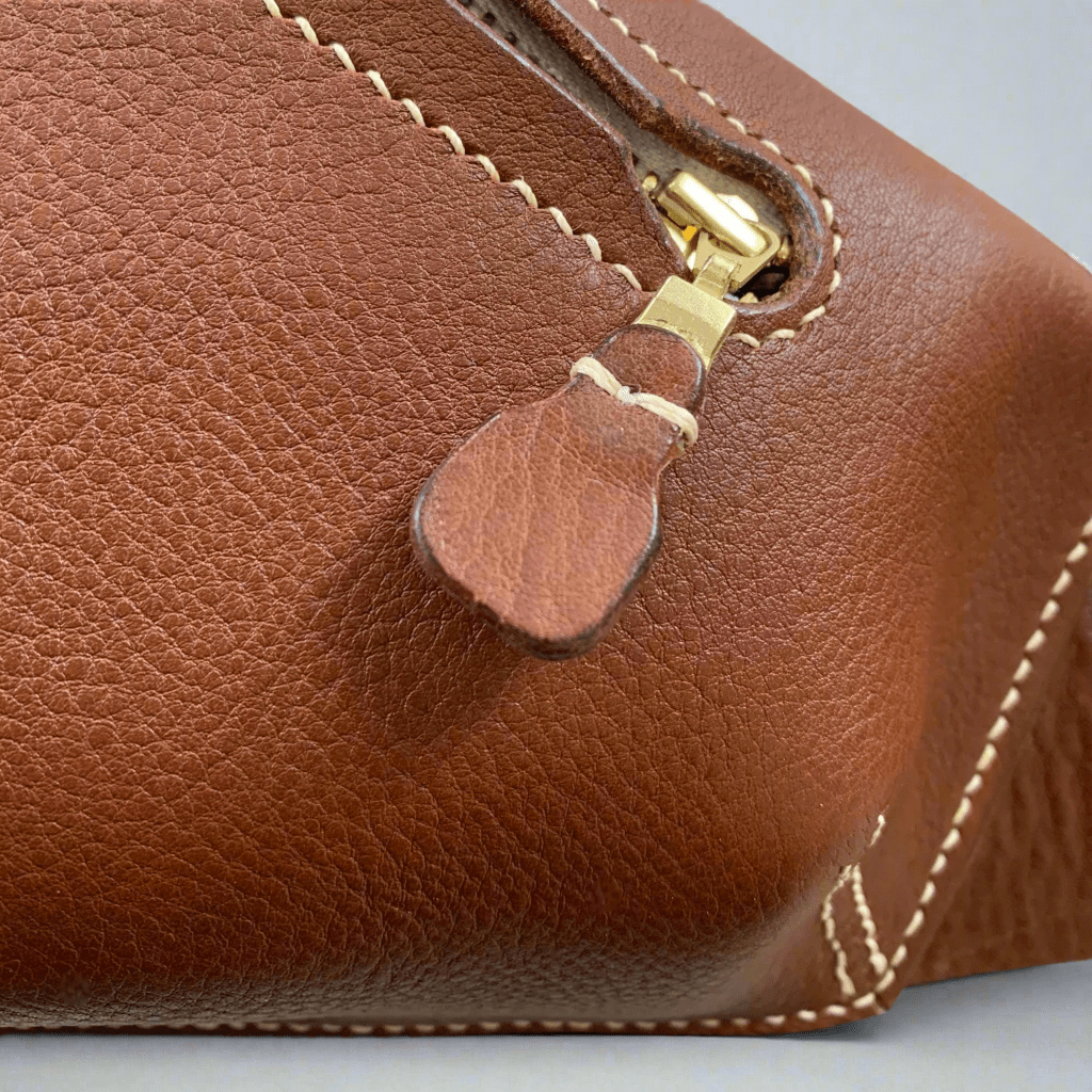 Leather zip pull detail of the elton cross body bag