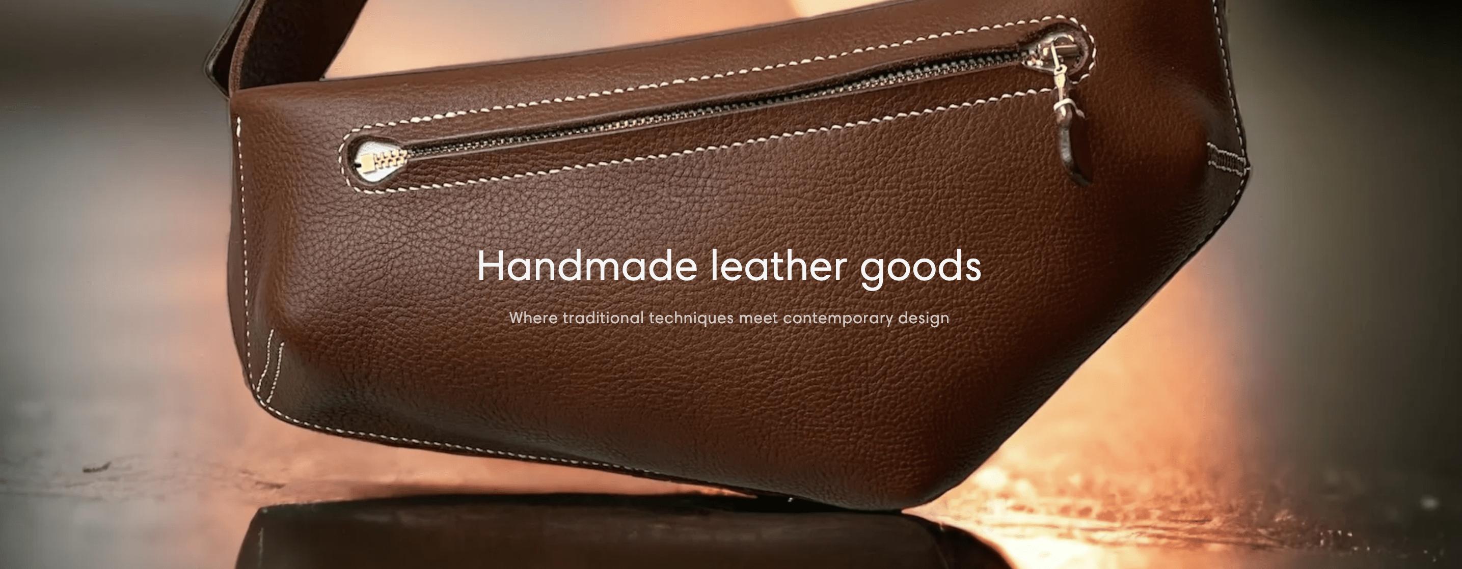 Dark tan asymmetric belt bag with cream stitching and zip fastening