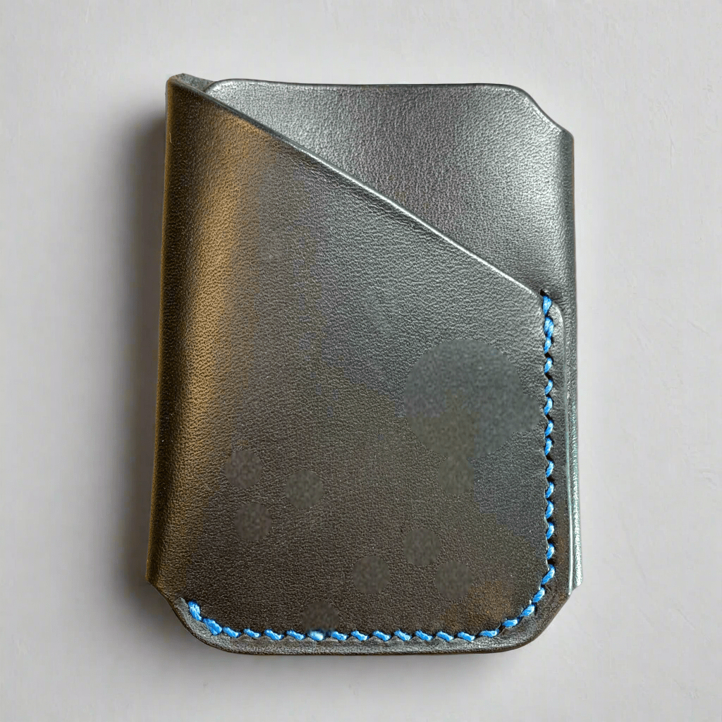 A black vegetable tanned leather wrap wallet with blue hand stitching