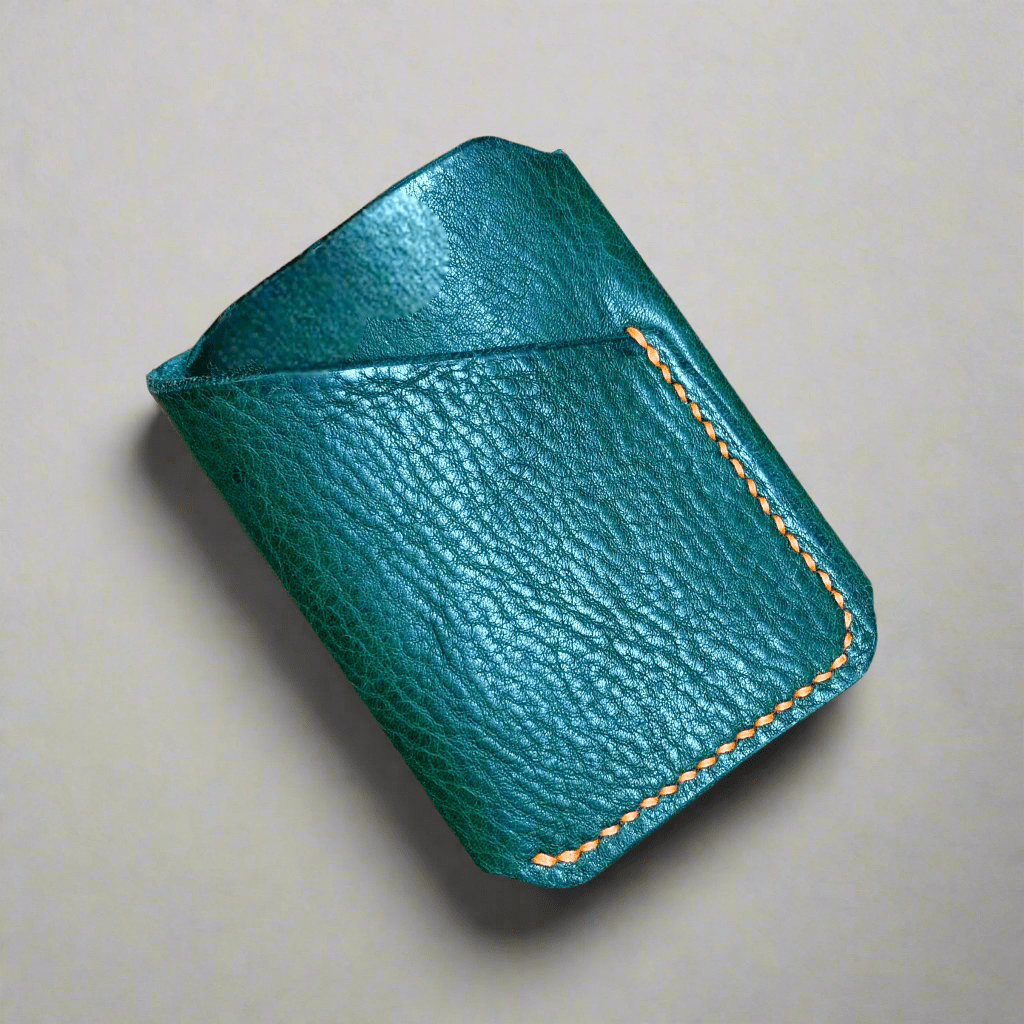 A wrap card wallet in green leather with orange stitching