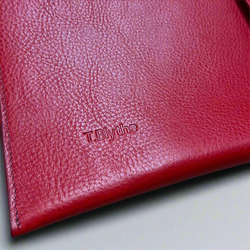 close up of a customised ipad case in red leather. Has a name embossed into leather 